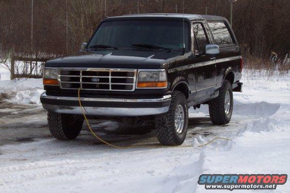1995 Ford Bronco parked in snow, front passenger side visible