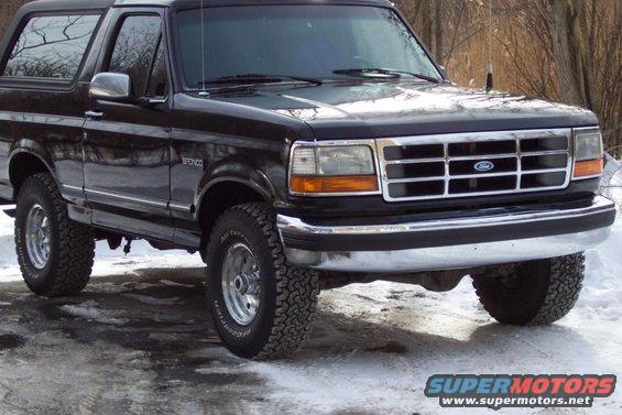 Black Ford Bronco with chrome grille and trim, parked on a snowy surface