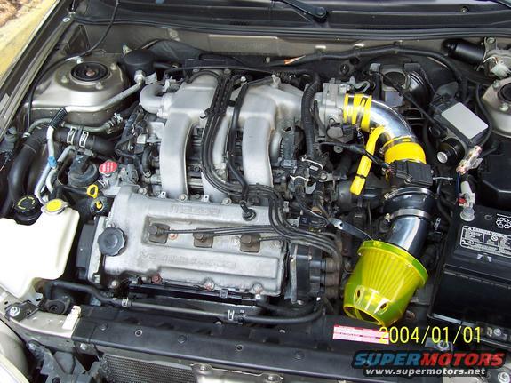 Engine bay with aftermarket yellow intake filter and MAZDA branding on engine block