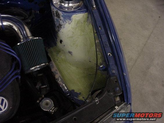 Engine bay with blue paint, green air filter, and exposed metalwork