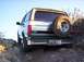 1996 Ford Bronco - This 1996 Ford Bronco is seen from the rear, with its spare tire mounted externally, navigating a rocky off-road path.
