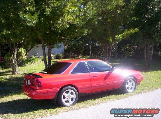Red 1991 Mazda MX-6 coupe, 3q-front view, parked on grass