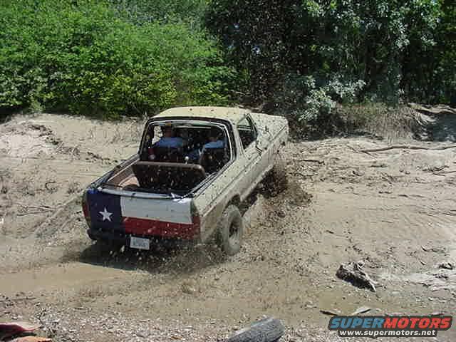 1978 Ford Bronco in mud, rear view with Texas flag tailgate