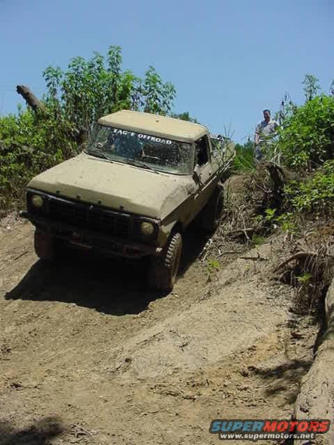 Tan Ford F-Series truck driving up a dirt hill off-road. Text on windshield reads "ZAG E OFFROAD"