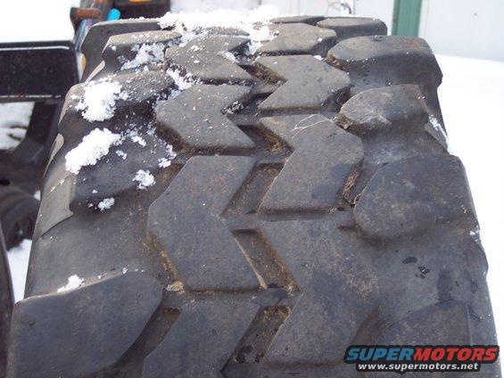 Close-up of a large tire tread with snow on it