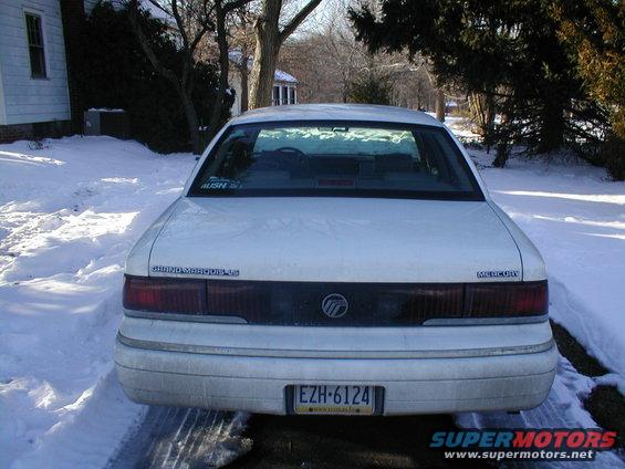 White Mercury Grand Marquis parked in snow, rear view. License plate EZH-6124
