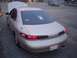 2002 Ford Taurus - A gold sedan is parked with its hood up, viewed from the rear, with another vehicle visible in the background.