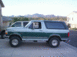 1996 Ford Bronco - A two-tone green and white Ford Bronco is parked outside on a sunny day.