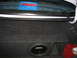 1995 Ford Taurus - The interior of a car trunk shows a subwoofer and other items, with a third brake light visible above.