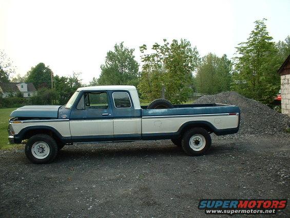 Side view of a blue and white 1978 Ford F-250 pickup truck with a spare tire in the bed
