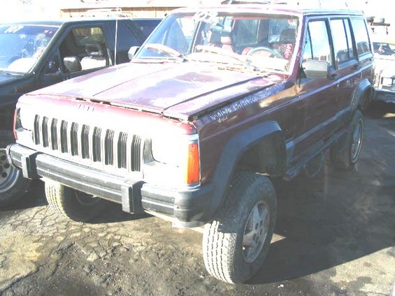 Maroon Jeep Cherokee XJ parked next to another SUV