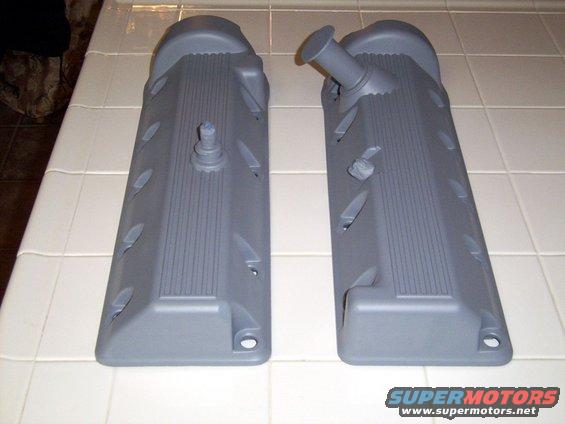 Two grey valve covers on a tiled surface