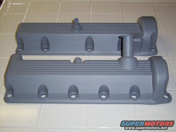 Two gray valve covers with ribbed tops and bolt holes