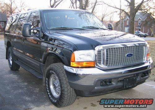 Black Ford Excursion SUV parked on a driveway, front 3/4 view. Chrome grille and headlights visible