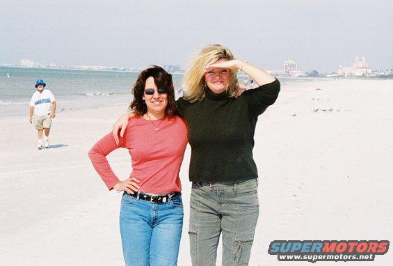 Two women on a beach, one shielding her eyes