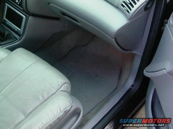 Passenger side interior shot showing light gray leather seat, floor mat, and dashboard area