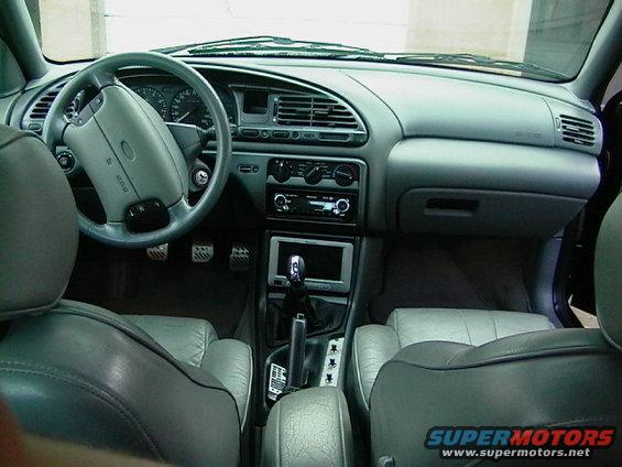 Gray leather car interior with dashboard, steering wheel, center console, and seats visible
