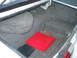 1988 Mercury Grand Marquis - The trunk interior shows a spare tire well, a red tool case, and a black box, with carpeting throughout.