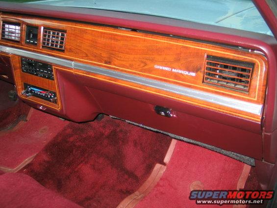 Dashboard with woodgrain trim, red carpet, and "Grand Marquis" badging