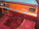 1988 Mercury Grand Marquis - The interior of a 1988 Mercury Grand Marquis shows woodgrain trim on the dashboard and red carpeting.