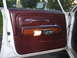 1988 Mercury Grand Marquis - Interior door panel of a 1988 Mercury Grand Marquis, wood grain trim and maroon upholstery.