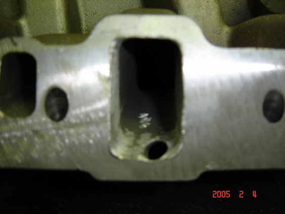 Close-up of a cylinder head intake port face with machined surface and ported runner