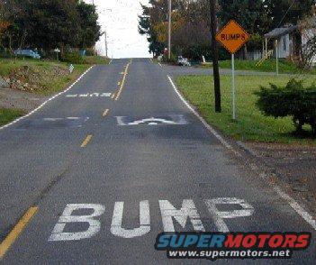 road with multiple speed bumps painted on it and a sign that says "BUMPS"