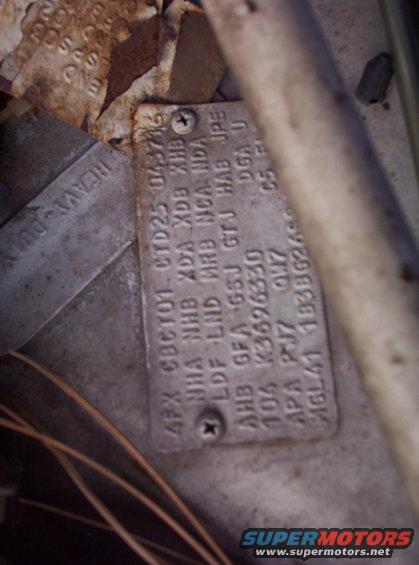 Vehicle identification plate with stamped alphanumeric codes and text