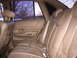 1992 Ford Crown Victoria - The interior of a car shows tan leather seats and door panels, with a view of bare trees and snow outside.