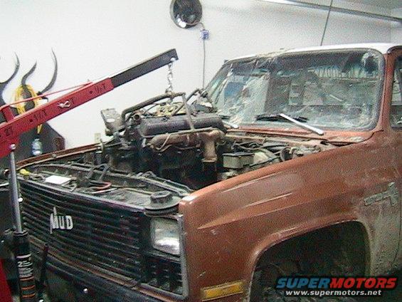 Truck with engine being lifted out by a crane. Grille says MUD