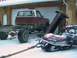 1981 Chevrolet C/K Pickup - A 1981 Chevrolet C/K Pickup chassis sits in the snow, tethered to a Polaris snowmobile.