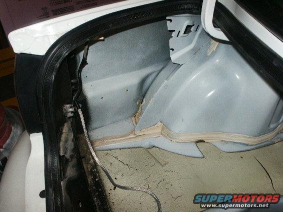 Interior of a car trunk showing sound dampening material and wiring