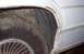 1985 Ford Crown Victoria LTD - Rust is visible on the fender and wheel well of a white car, indicating poor condition.