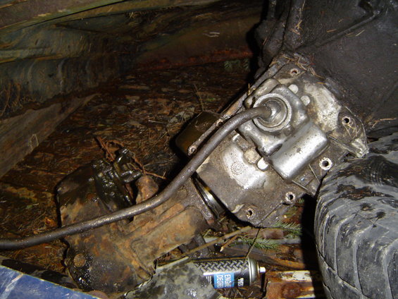 close-up of a dirty vehicle transmission and a tire