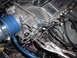 1994 Ford Probe - Close-up of a custom intake manifold assembly, showing the throttle body, blue intake hose, and wiring, with vise grips attached to a cable.