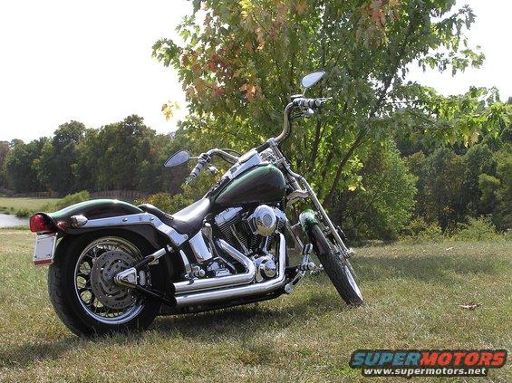 Green motorcycle parked on grass, side view, chrome details visible