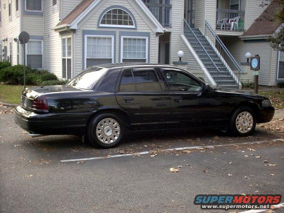 Black sedan parked in front of a building. The car is a 2001 Ford Crown Victoria