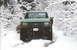 1990 Ford Bronco - A green Ford truck navigates a snowy, wooded path.