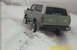 1990 Ford Bronco - A green Ford Bronco with a white top navigates a snowy incline.