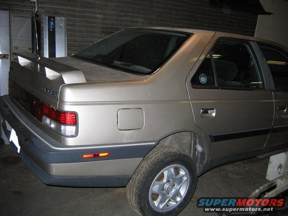 Rear quarter view of a gold 1989 Peugeot 405 sedan with a spoiler