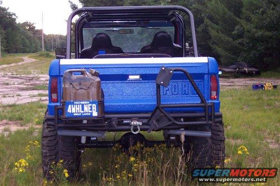 Blue 1974 Ford Bronco rear view, with a jerry can and spare tire carrier mounted on the tailgate