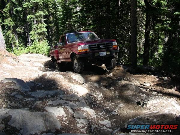 1992 Ford F-150 navigating a rocky off-road trail in a forest