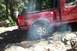 1992 Ford F-150 - This red 1992 Ford F-150 is navigating a rocky trail, with smoke billowing from its rear tire.