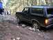 1995 Ford Bronco - A black 1995 Ford Bronco tackles a challenging off-road course with onlookers present.