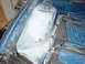 1998 Volkswagen Jetta - Close-up of a blue engine bay strut tower, showing primer and a black plastic component. The "SUPERMOTORS" watermark is visible.