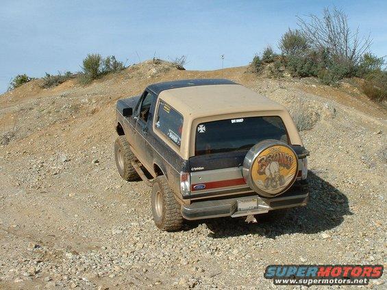 1991 Ford Bronco rear view on a dirt trail with a spare tire cover
