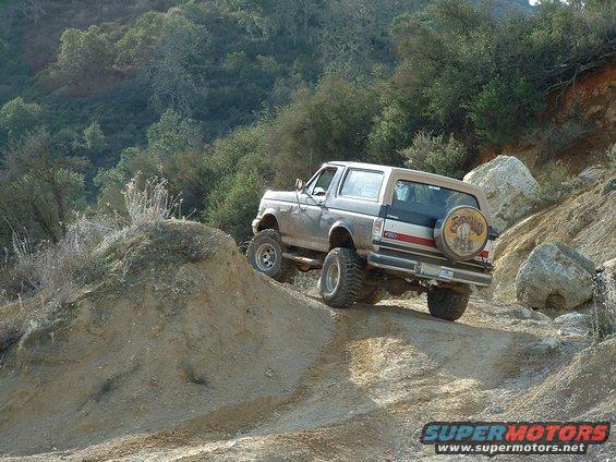 1991 Ford Bronco climbing a steep dirt hill, rear view