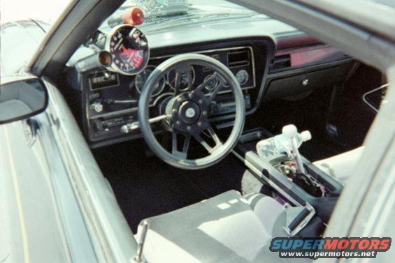1978 Ford Mustang II interior, driver's side view, aftermarket tachometer and gauges on dash, custom steering wheel, automatic shifter