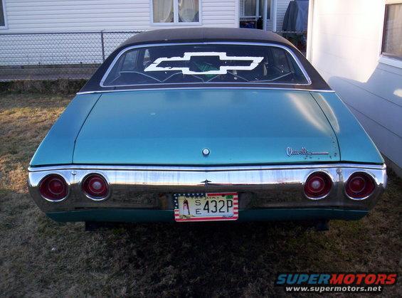 1971 Chevrolet Chevelle with black vinyl top and large Chevrolet bowtie decal on rear window. Teal paint, chrome bumper, and quad taillights