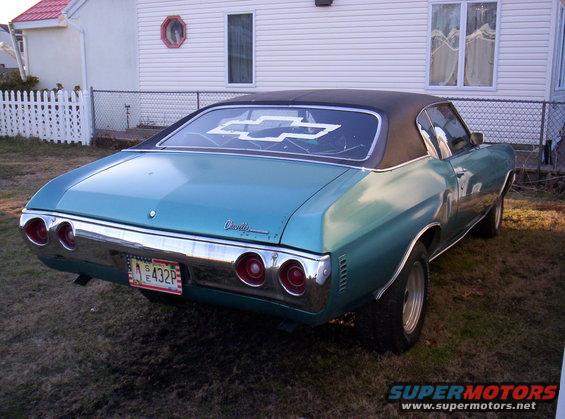Rear view of a 1971 Chevrolet Chevelle with a black vinyl roof and a large Chevrolet bowtie decal on the rear window